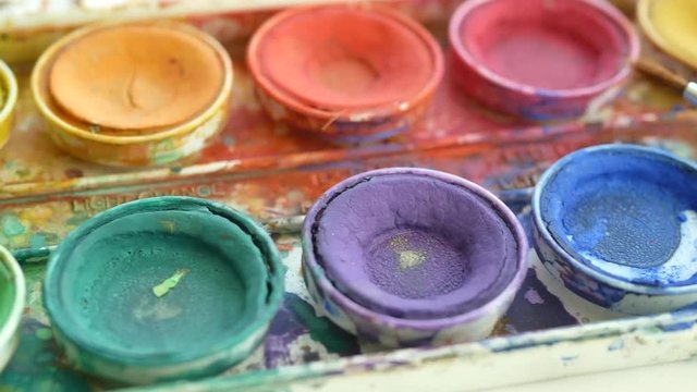 Artists watercolor palette and paintbrush messy with colorful paint SLIDE RIGHT