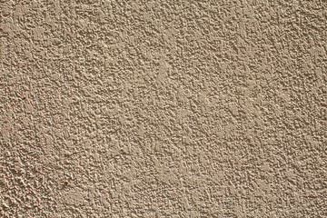 A textured beige plaster's wall as a background