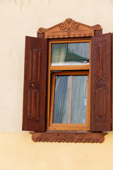 Brown wooden window with open shutters