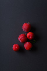 Red sweet cherry plums on dark background. Overhead view