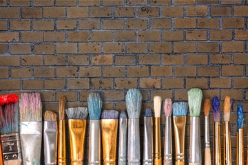 Row of artist paint brushes on background