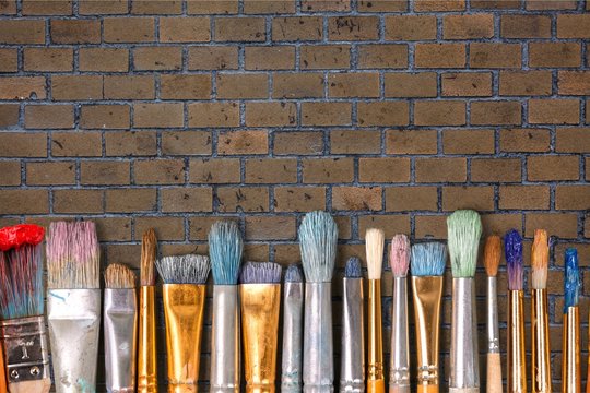 Row of artist paint brushes on background