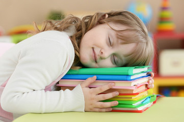 Cute schoolgirl sleeping on table