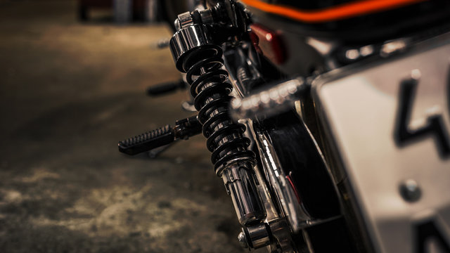 Close up view on rear shock absorber for a motorcycle. Chrome on moto parts. Wallpaper. Copy space. Rear view
