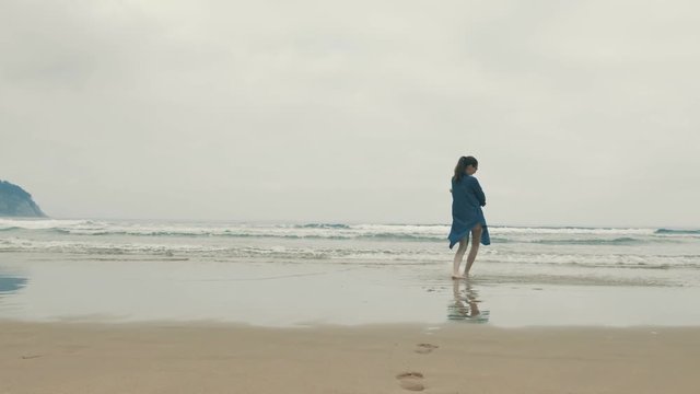 4 k beautifull young girl, mother walking and taking time with her cute little baby, among the Cantabrian coast, in the bay of Atlantic ocean at cloudy morning