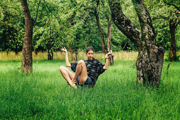 beautiful stylish hipster girl levitating with peaceful feelings in apple garden in summer - obrazy, fototapety, plakaty