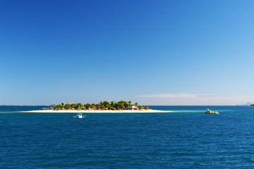 An island from a distance with a blue sky.