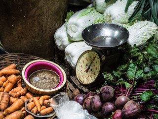 vintage weighing scale and vegetables for sale in a shop at traditional central market in port...