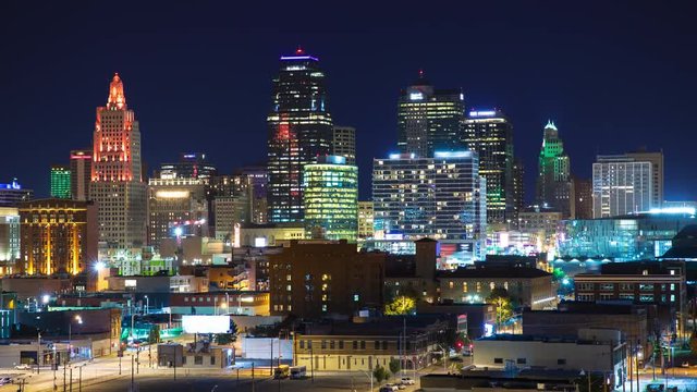 Vibrant Kansas City Night Cityscape Timelapse with Moving Lights from Colorful Skyscrapers and Street Traffic under a Clear Blue Evening Sky