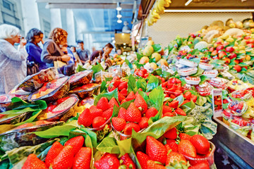 Food market with fruits in Barcelona. Fresh Red strawberry at foreground.