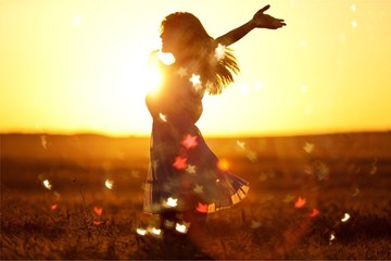 Young woman on field under sunset light