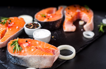 Raw salmon steak on black stone, prepared for cooking