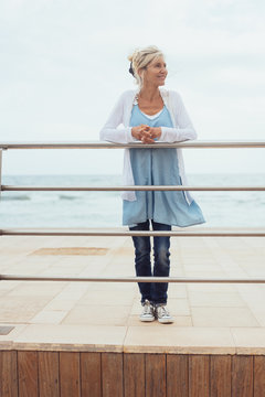 Casual trendy blond woman standing on a pier