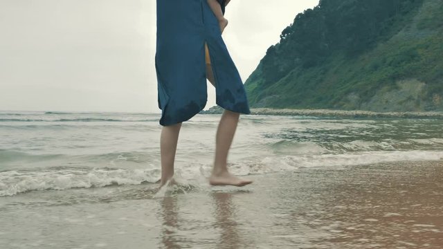 4 k beautifull young girl, mother walking and taking time with her cute little baby, among the Cantabrian coast, in the bay of Atlantic ocean at cloudy morning