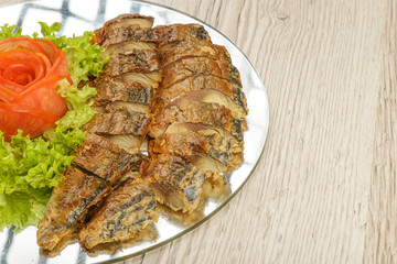 Sliced herring on a plate with herbs.