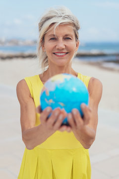 Attractive woman holding out a world globe