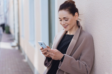 Attractive stylish woman using a mobile in town
