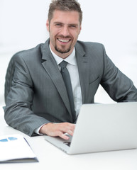 closeup.smiling businessman working with laptop