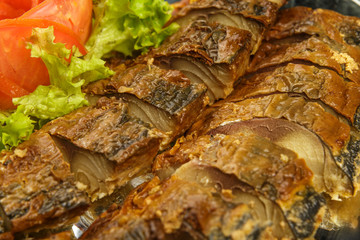 Sliced herring on a plate with herbs.