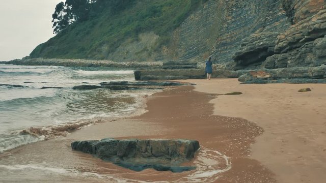 4 k beautifull young girl, mother walking and taking time with her cute little baby, among the Cantabrian coast, in the bay of Atlantic ocean at cloudy morning