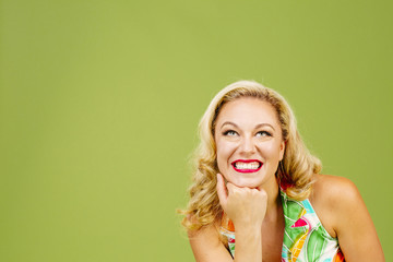 The big happy smile, portrait of a beautiful blonde woman looking up, isolated on green studio background