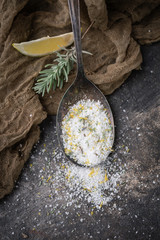 Lemon Lavender Herb Salt in Tarnished Spoon on Black Background with Fresh Sprig of Lavender