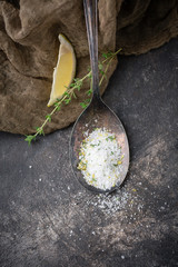 Lemon Thyme Herb Salt in Tarnished Spoon on Black Background with Fresh Sprig of Thyme