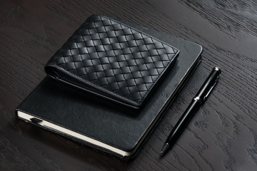 men's black wallet with notebook and pen