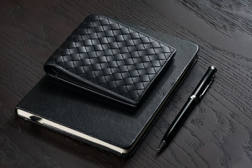 men's black wallet with notebook and pen