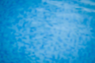 Defocused blurry recreational holiday swimming pool sunny tropical background. Unfocused blurred outdoors for having fun on travel vacation summertime relax.