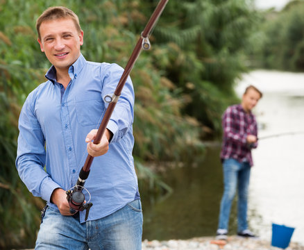 Man fishing using rod on lake