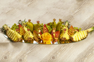 Very nice and artistically sliced fruits on a platter.