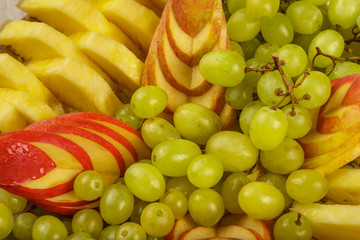 Very nice and artistically sliced fruits on a platter.