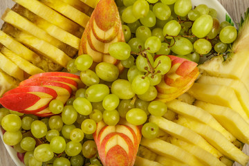 Very nice and artistically sliced fruits on a platter.