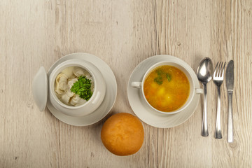 Complex lunch with dumplings and a bun on a wooden background.