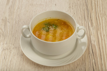 Plate with soup in a white plate on a wooden background.