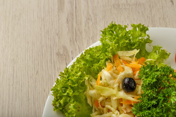 Fresh cabbage salad with greens on a plate.