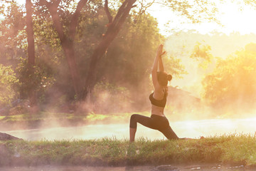 Healthy Lifestyle.  Silhouette meditation yoga woman for relax vital and energy in the morning at the hot spring park.  Healthy Concept