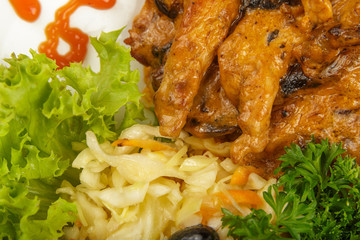 Roast with pasta and salad on a plate.