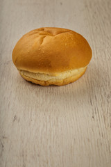 Fresh ruddy bun on a wooden background.