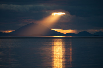 A ray of light descending from the heavens over the water