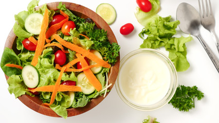 Mixed vegetables salad with cream on white background.