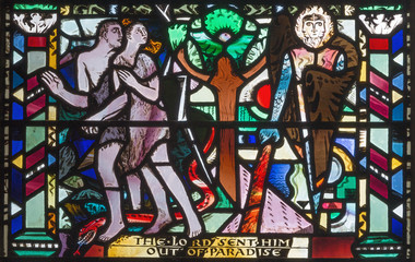 Fototapeta na wymiar LONDON, GREAT BRITAIN - SEPTEMBER 16, 2017: The Expulsion of Adam and Eve from Paradise on the stained glass in church St Etheldreda by Charles Blakeman (1953 - 1953).