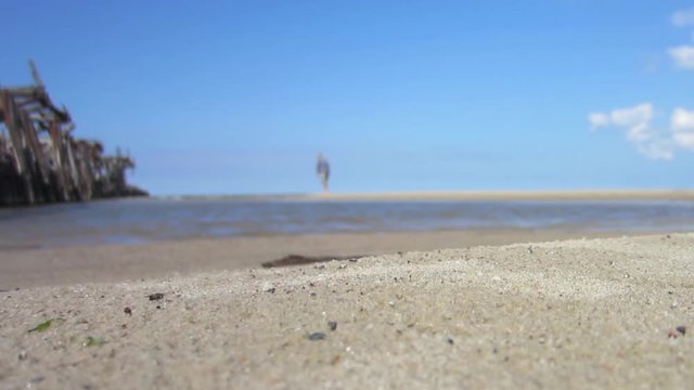 Unfocused man steals someone's things on the sandy beach