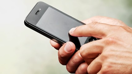 Hands holding smartphone on background