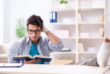 Young student man with hand injury preparing for the exams 