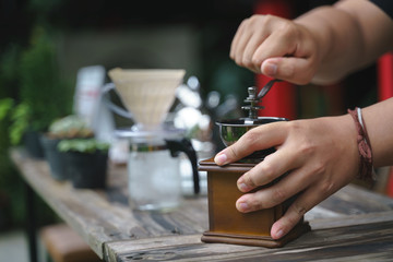 Fototapeta na wymiar Hand crushing beans with coffee grinder