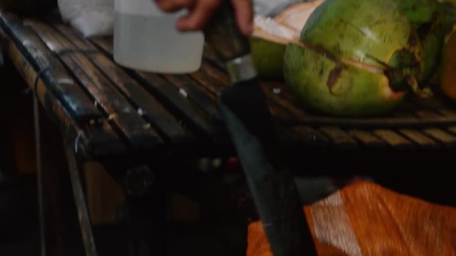A coconut vendor choose a coconut to open it to make a buko juice buko saladsand