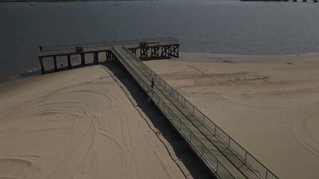 Aerial of Man walking onto pier - Perth Amboy