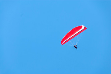 Hang glider soars through a pristine blue sky III